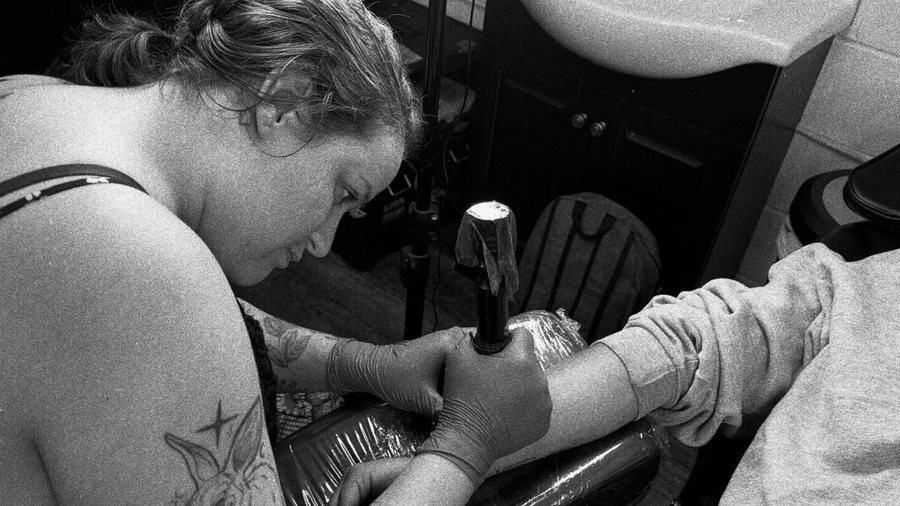 Ashlan tattooing a client