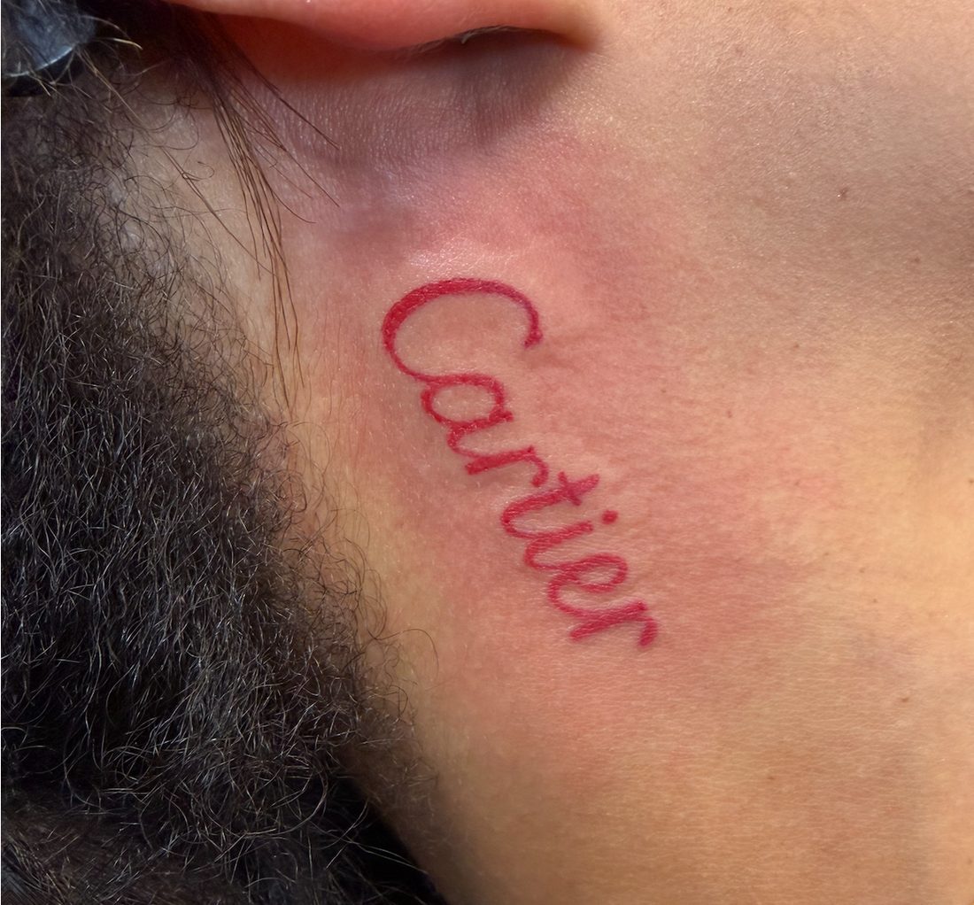 Red script lettering tattoo