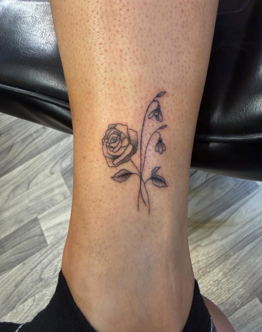 Fine-line rose tattoo on the ankle